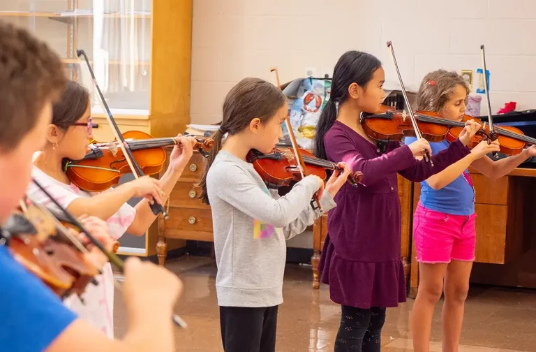 Children in a line, taking violin lessons